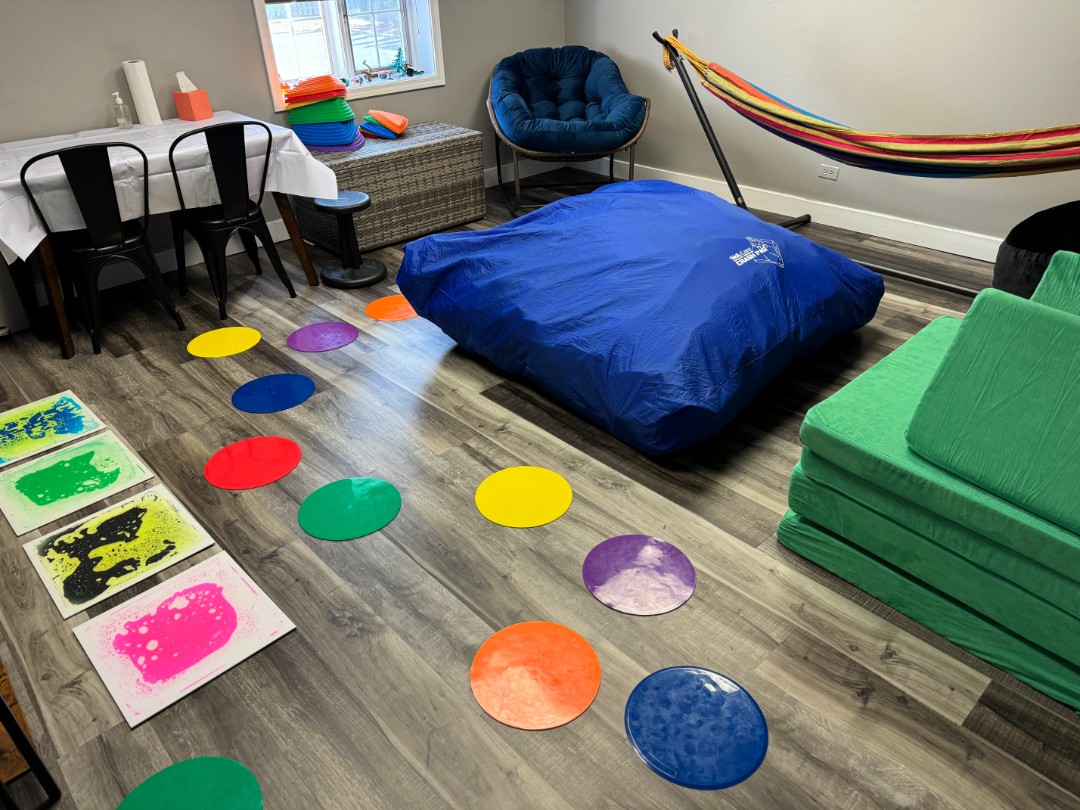 Kids room with colorful circles on the floor, paintings on square canvases, and a table for creating new art